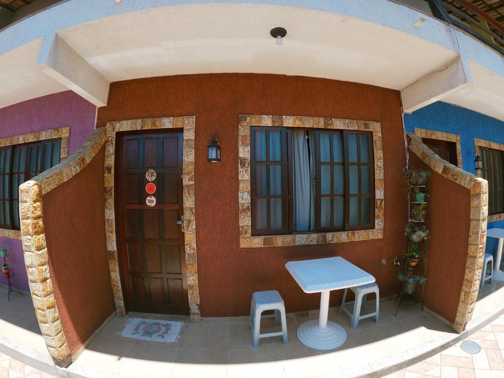 un modelo de casa con dos puertas y dos taburetes en Vila da Drika en Rio das Ostras