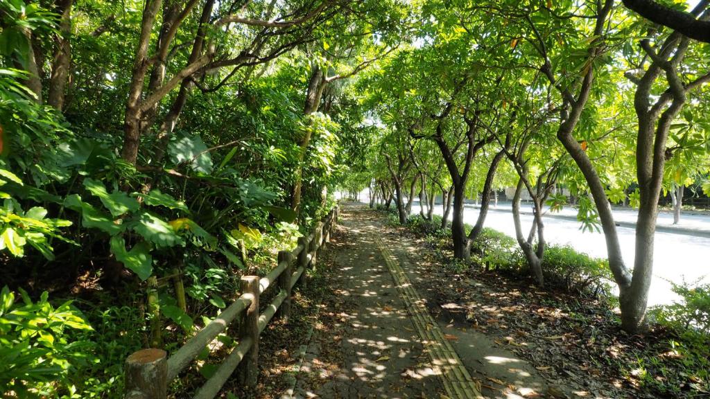 a path lined with trees next to a road at Crown Hotel Okinawa in Okinawa City