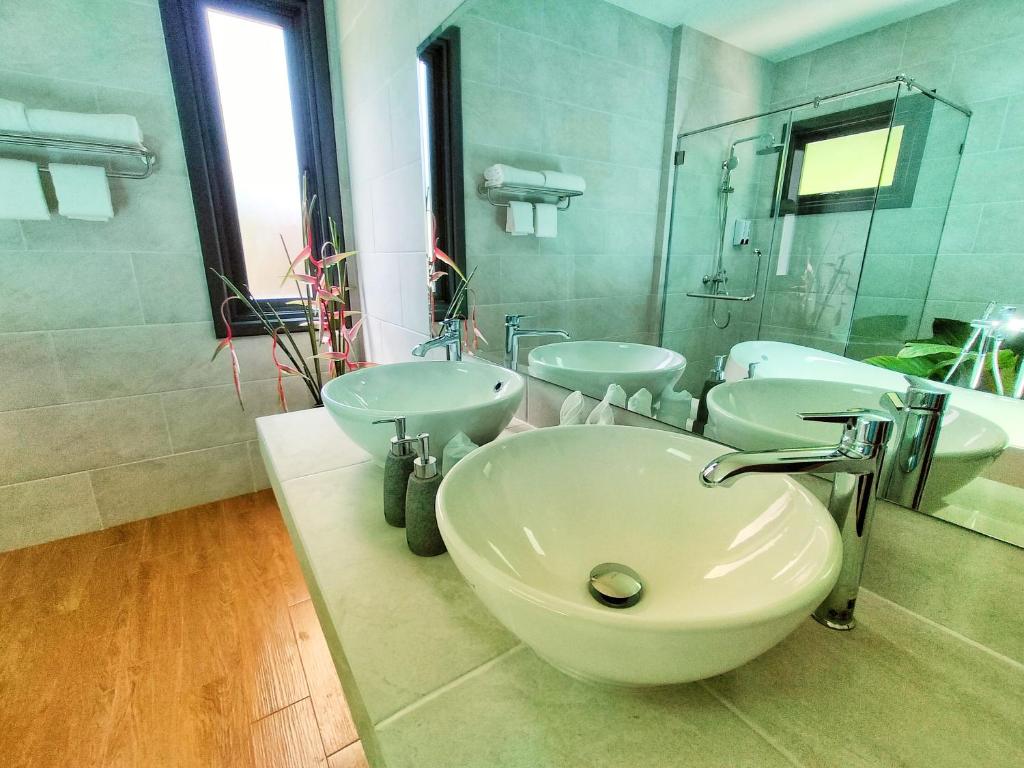 a bathroom with three sinks and a large mirror at Supalai Scenic Bay Resort And Spa, SHA Extra Plus in Por Bay