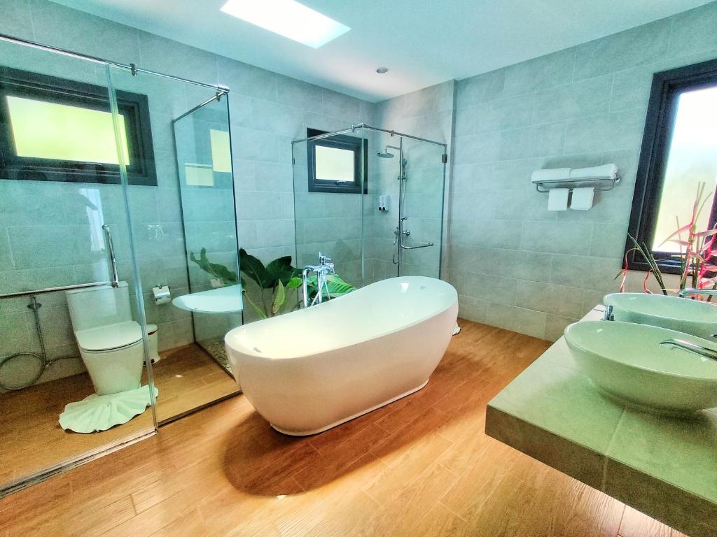 a bathroom with a large white tub and a sink at Supalai Scenic Bay Resort And Spa, SHA Extra Plus in Por Bay