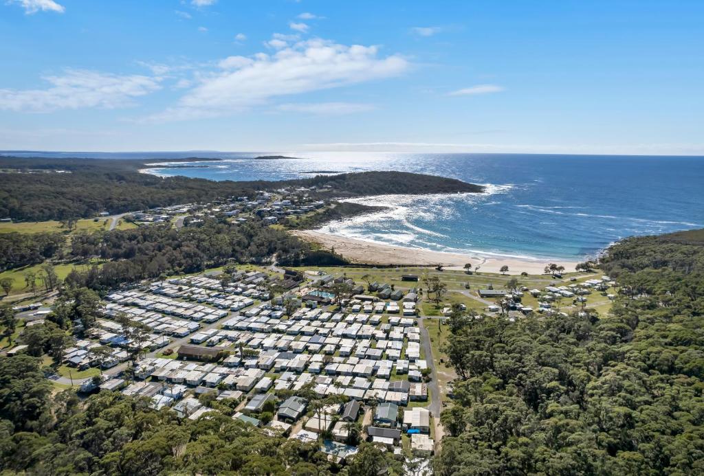 - une vue aérienne sur une plage avec des maisons et l'océan dans l'établissement Ingenia Holidays Merry Beach, à Kioloa