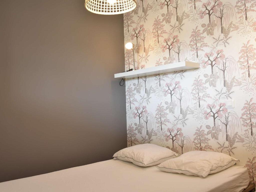 une chambre avec un lit avec un papier peint fleuri dans l'établissement Appartement 2 pièces rénové, climatisé, avec balcon et parking privé - 4 couchages, Gruissan - FR-1-229-783, à Gruissan