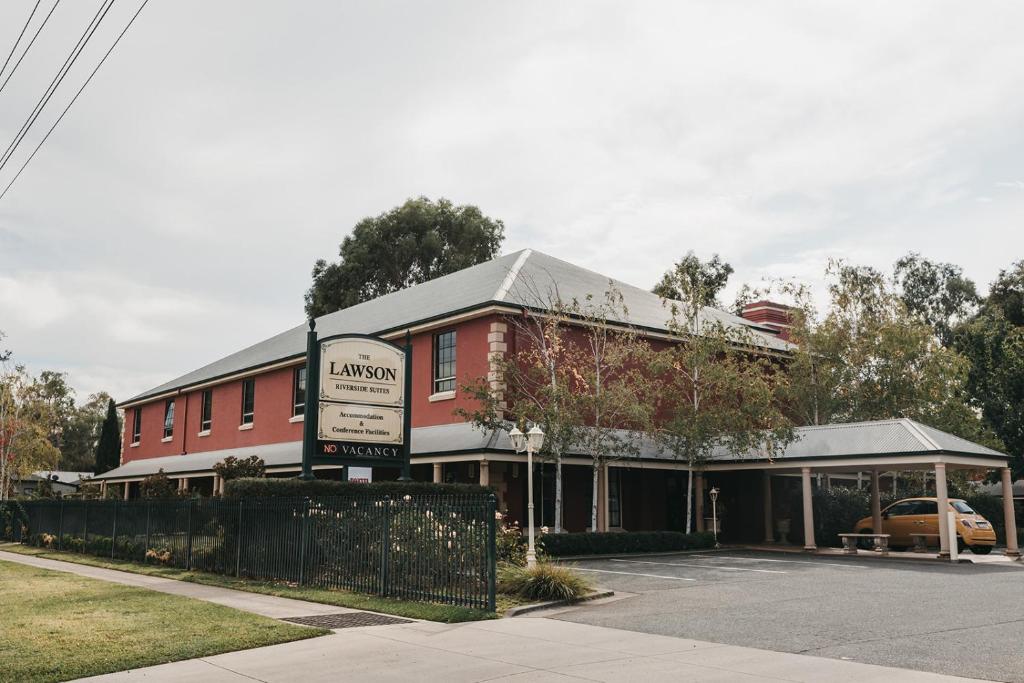 un edificio rosso con un cartello davanti di The Lawson Riverside Suites a Wagga Wagga