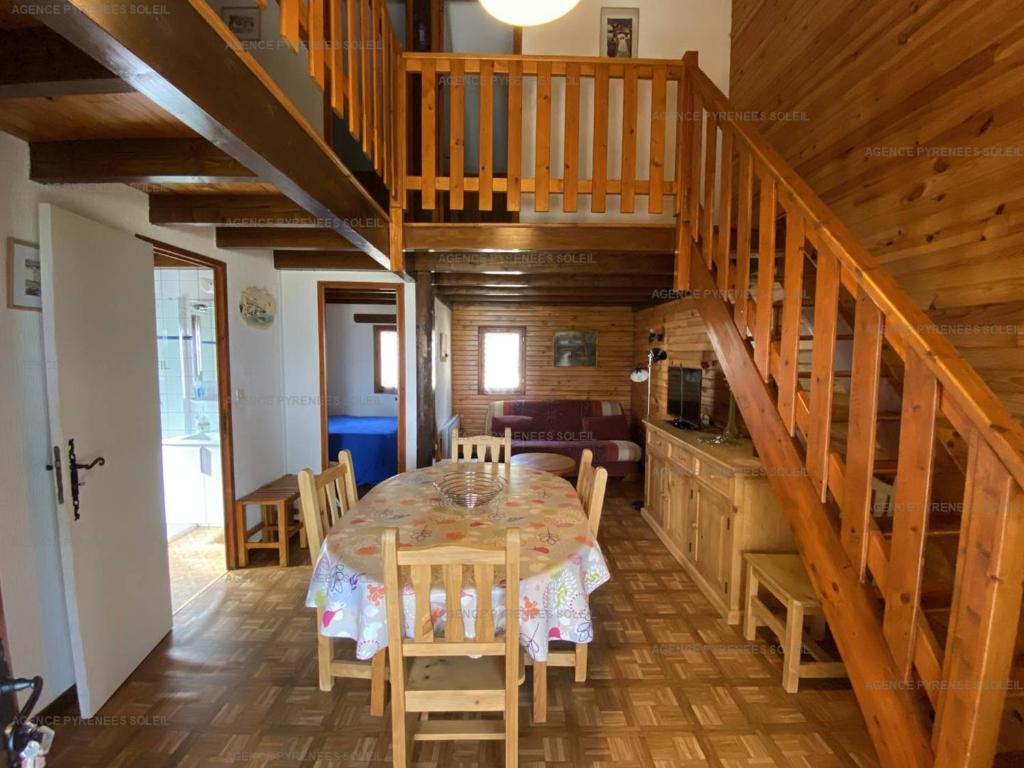 une salle à manger avec une table et un escalier dans l'établissement Chalet 6 pers. Les Angles avec garage et véranda - FR-1-295-136, aux Angles
