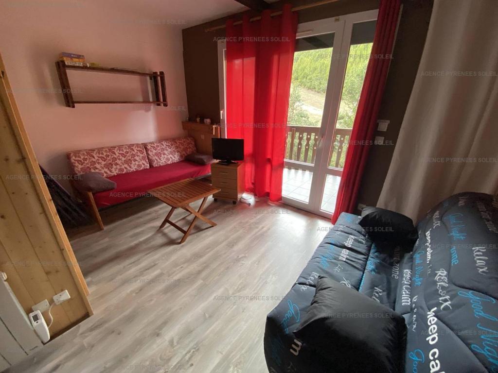 un salon avec un canapé et une fenêtre dans l'établissement Appartement T2 au pied des pistes, 4 couchages, Les Angles - Balcon, Wifi, Parking - FR-1-295-137, aux Angles