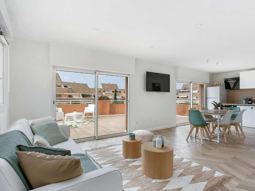 un salon blanc avec un canapé et une table dans l'établissement Appartement lumineux 3 pièces - Neuf 2021 - Climatisé - Grande terrasse - Parking - WIFI inclus - FR-1-326-730, à Marseillan