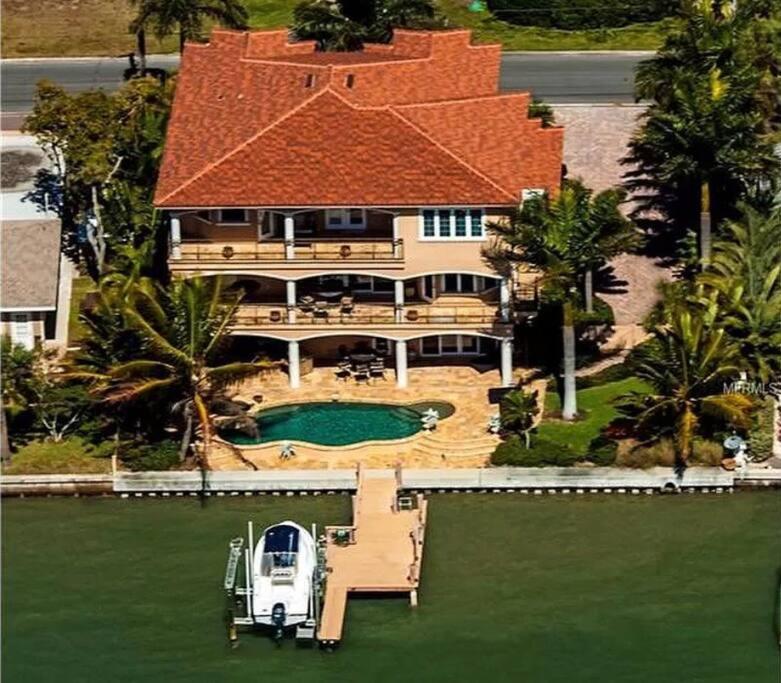 an aerial view of a house with a boat in the water at Large Mediterranean Oasis - Water Views & Pool in Clearwater Beach