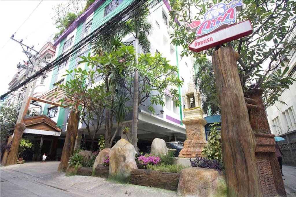 Um edifício com um cartaz de cocacola à frente. em Kaya Place em Bangkok