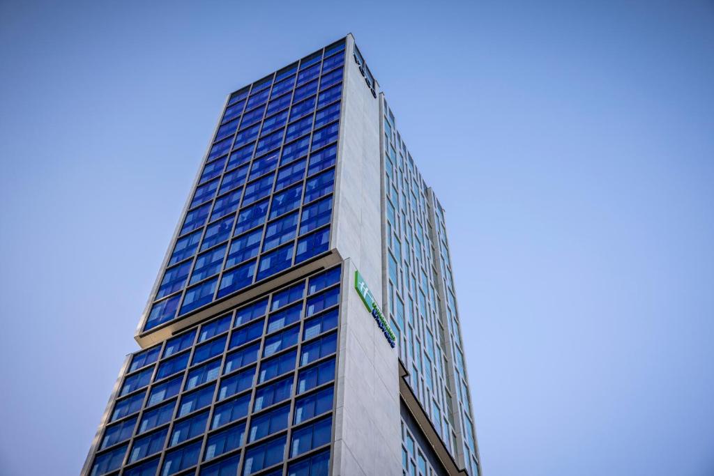 a tall building with blue windows on top of it at Holiday Inn Express Auckland City Centre, an IHG Hotel in Auckland