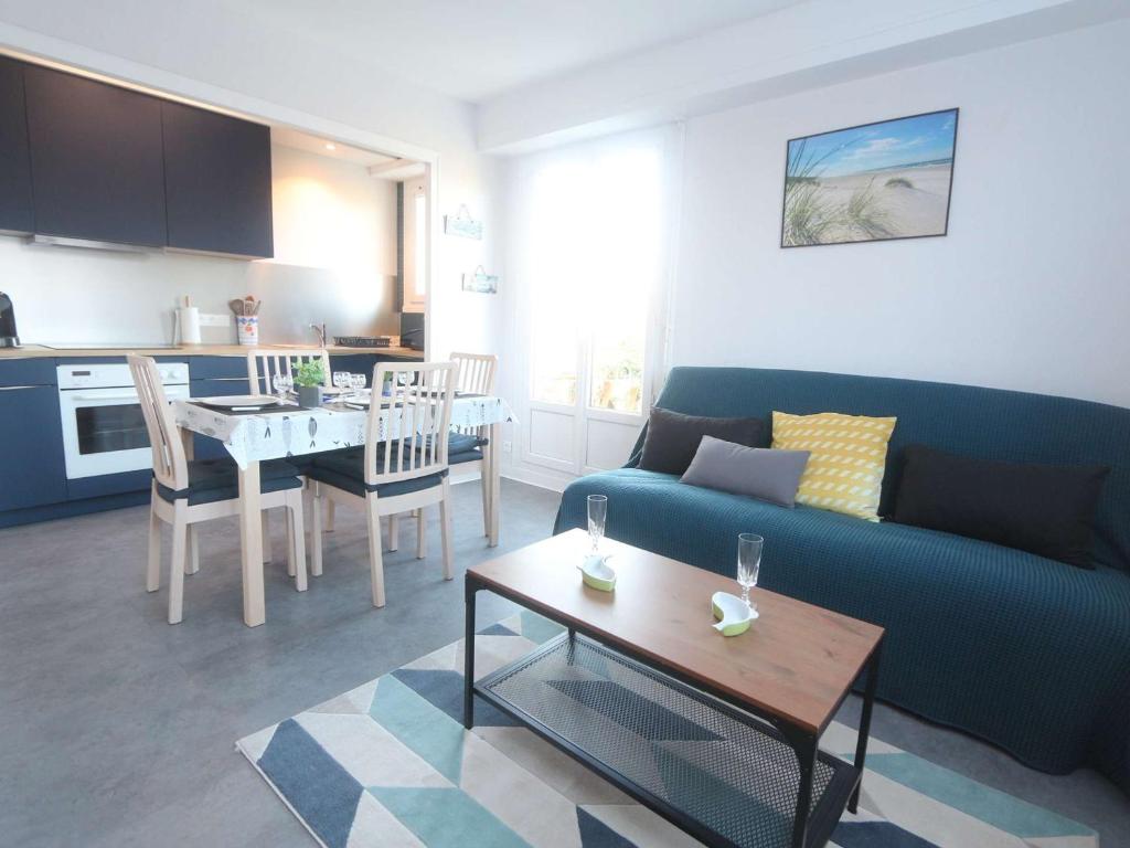 un salon avec un canapé bleu et une table dans l'établissement Appartement 3 étoiles à 150m de la plage du Letty, rénové, parking inclus - FR-1-481-97, à Bénodet