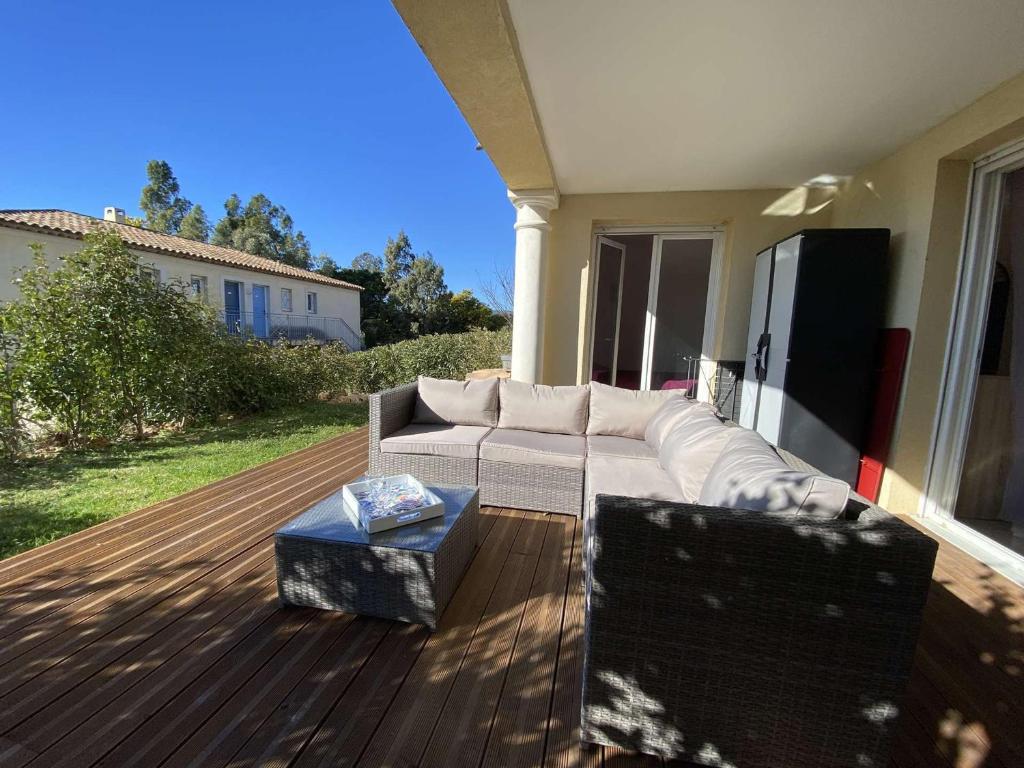 - un canapé blanc assis sur une terrasse en bois dans l'établissement Sainte-Maxime : 3 Pièces, 4 Couchages, Piscine, Calme, Proche Commerces et Aqualand - FR-1-226-476, à Sainte-Maxime