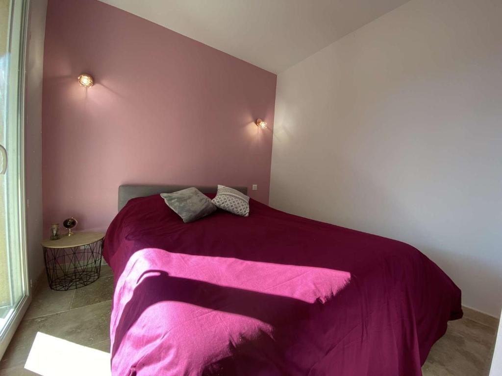 a bedroom with a bed with a purple blanket at Appartement Sainte-Maxime, 3 pièces, 4 personnes - FR-1-226-476 in Sainte-Maxime