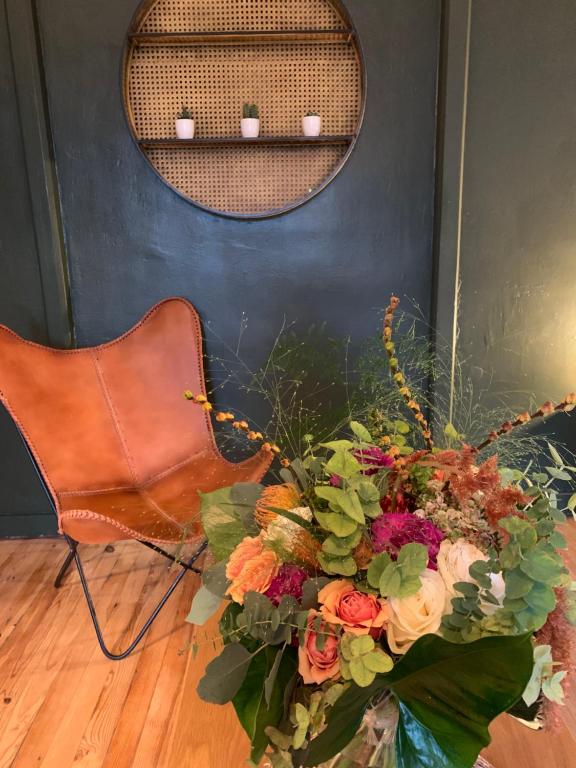 un bouquet de fleurs assis sur le sol à côté d'une chaise dans l'établissement La Ferme du Puy d'Or, à Limonest