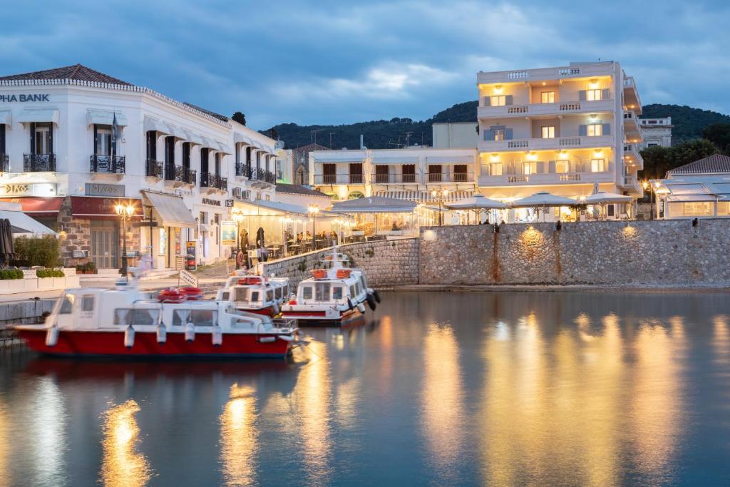 um grupo de barcos ancorados num rio com edifícios em Hotel Roumani em Spetses