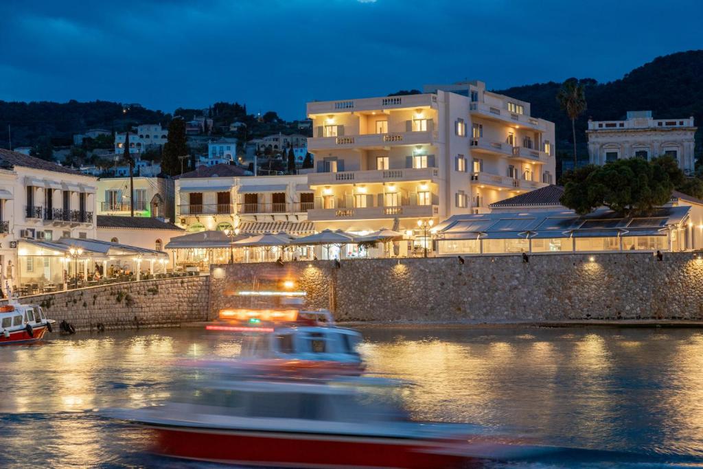 a boat in the water in front of a building at Hotel Roumani in Spetses
