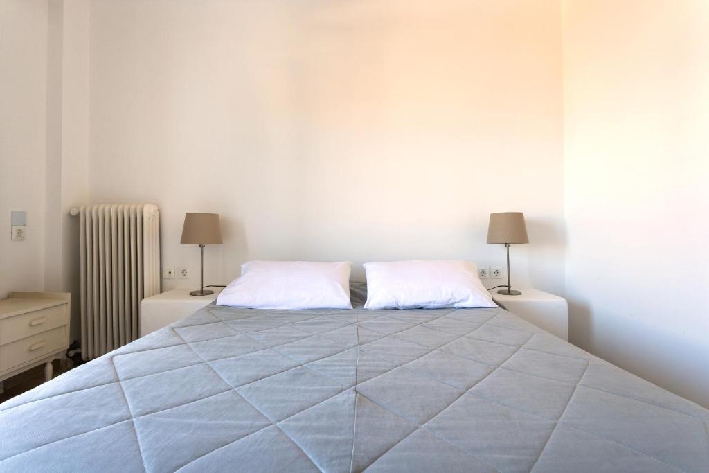 a white bedroom with a large bed with two pillows at Hotel Roumani in Spetses