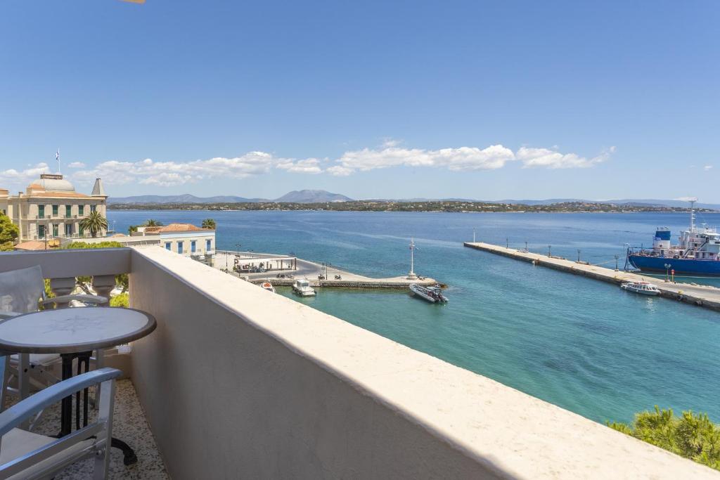 a balcony with a view of the water and a dock at Hotel Roumani in Spetses