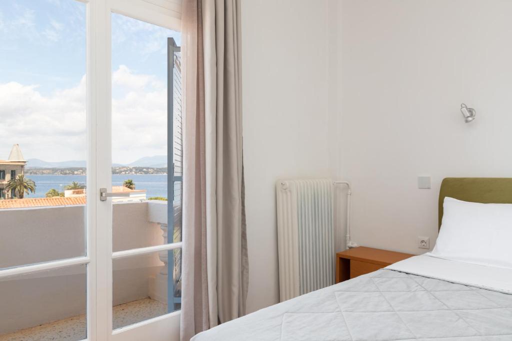 a bedroom with a bed and a view of the ocean at Hotel Roumani in Spetses