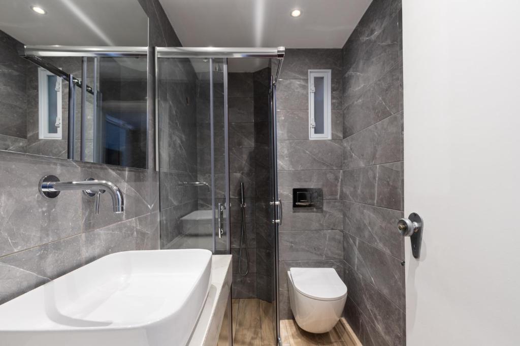 a bathroom with a shower and a sink and a toilet at Hotel Roumani in Spetses