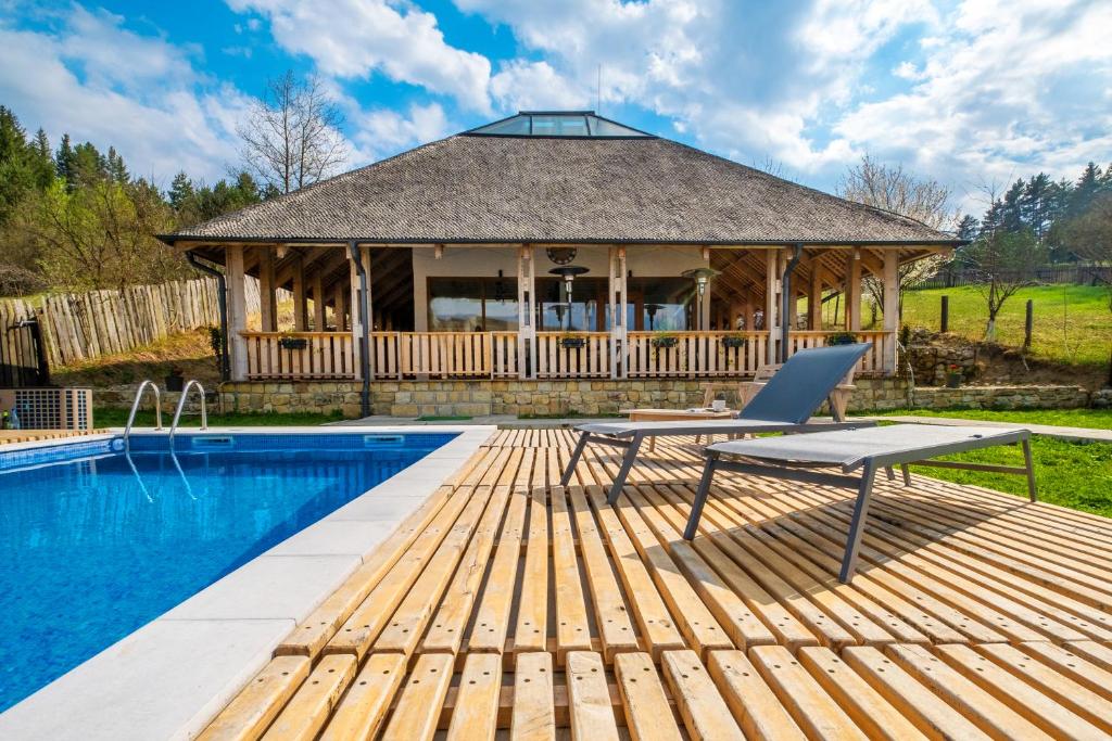 a house with a pool and a deck with a house at Casa Thymus in Soveja