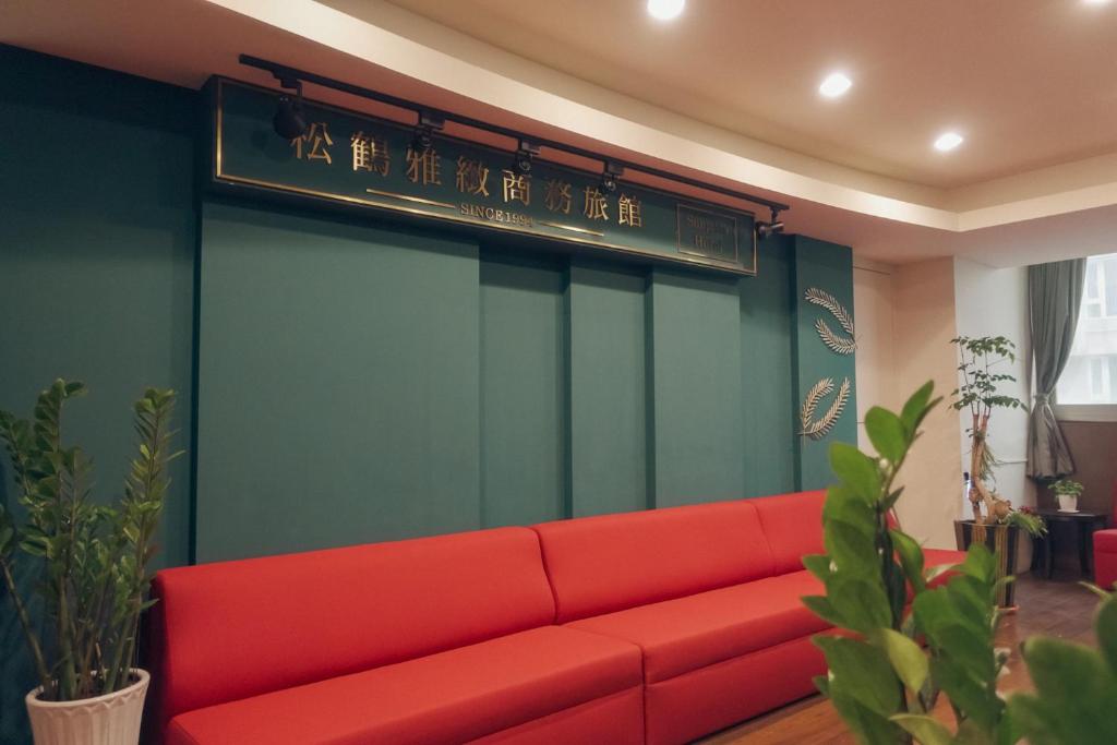 un sofá rojo en una habitación con un cartel en SongHo Hotel en Magong