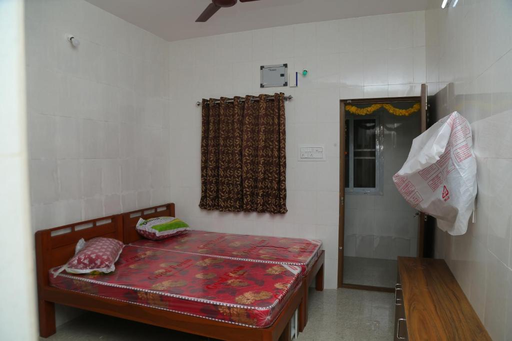 1 dormitorio con cama, mesa y ventana en Sri Lakshmi Residency, en Chennai