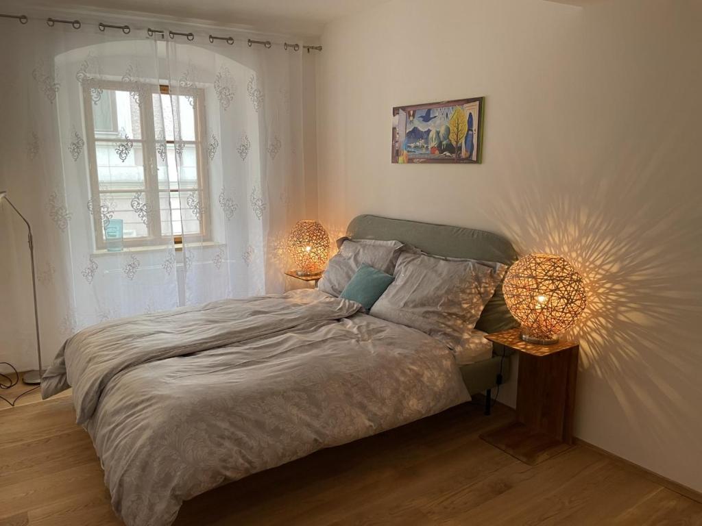 a bedroom with a bed with two lamps on it at Altstadt Bed&Bike in Gmunden