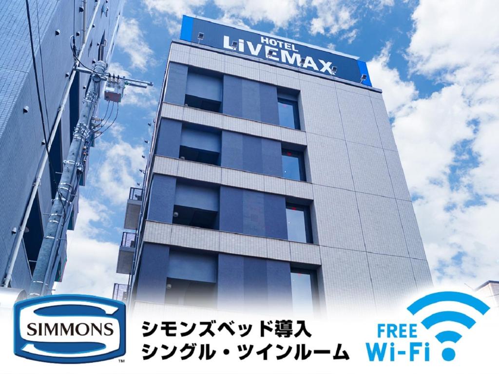 a building with a sign on the side of it at HOTEL LiVEMAX Saitama-Asaka-Ekimae in Asaka