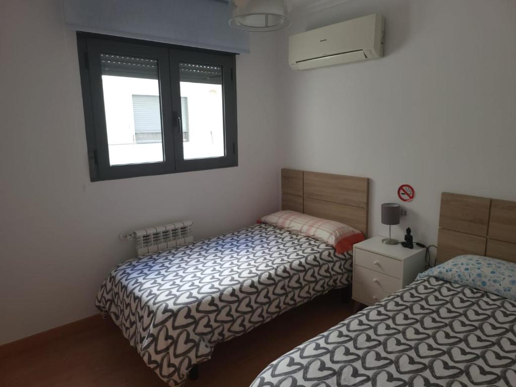 1 dormitorio con 2 camas y ventana en BioPark Home Valencia, en Valencia