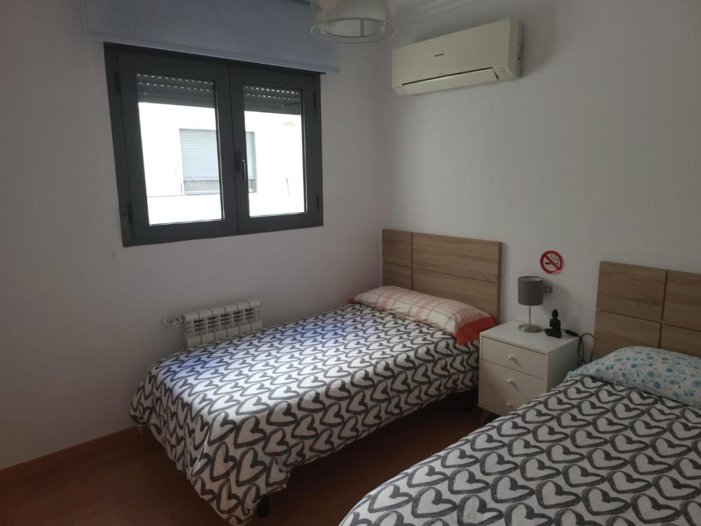 a bedroom with two beds and a window at BioHomeValencia in Valencia