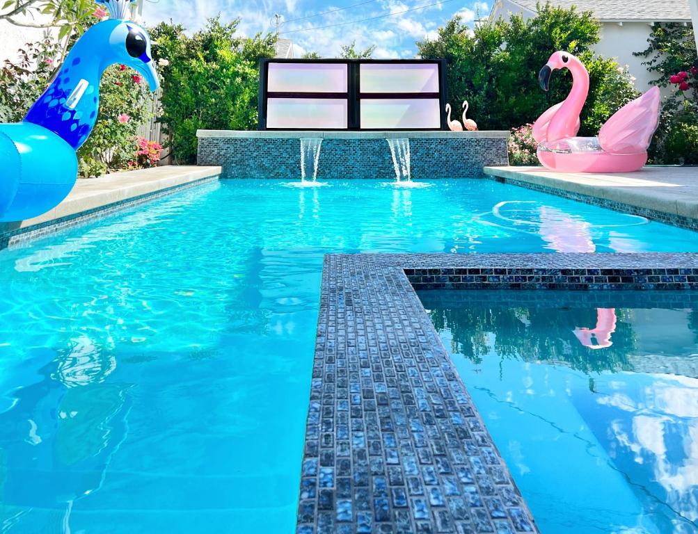 a swimming pool with two inflatable flamingos in the water at NoHo Luxury Oasis I saltwater pool-spa I sleeps up to 8 I 15 mins from Hollywood in Los Angeles