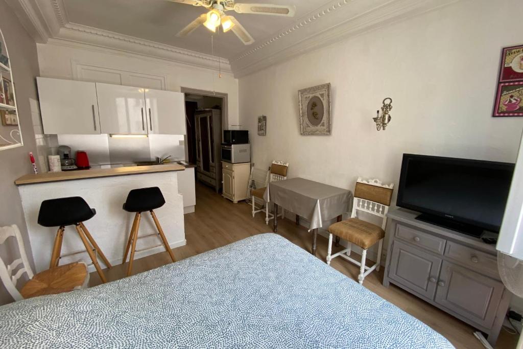 Il comprend un salon avec une télévision et une cuisine avec des chaises. dans l'établissement Studio Ideal vacation by the sea, à Juan-les-Pins