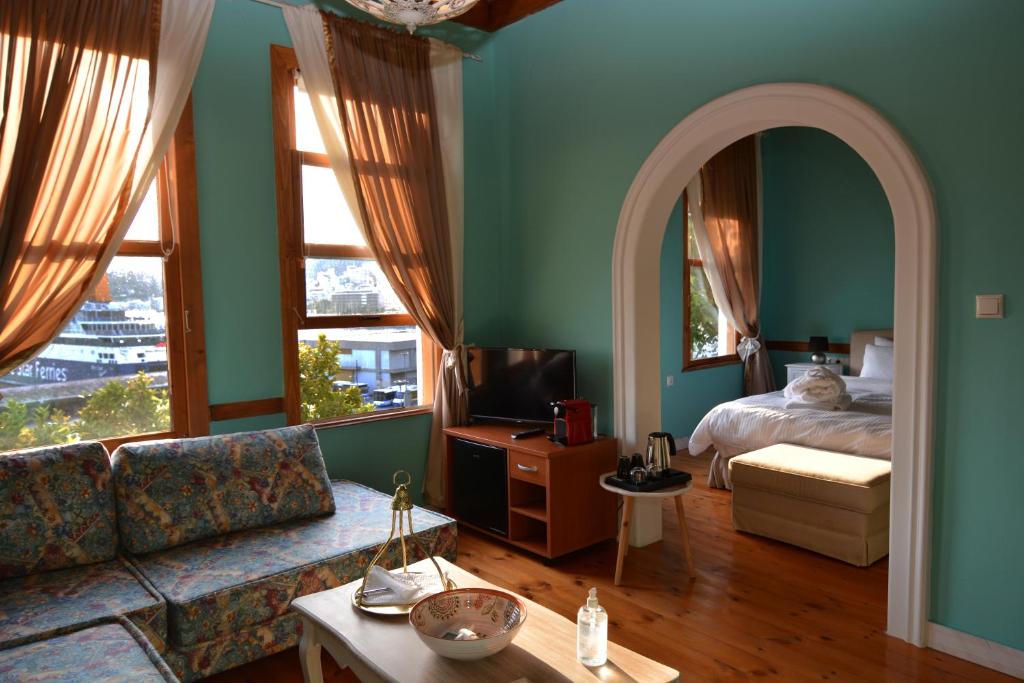 a living room with a couch and a bed at Amina Hanem Boutique Apartments in Kavala