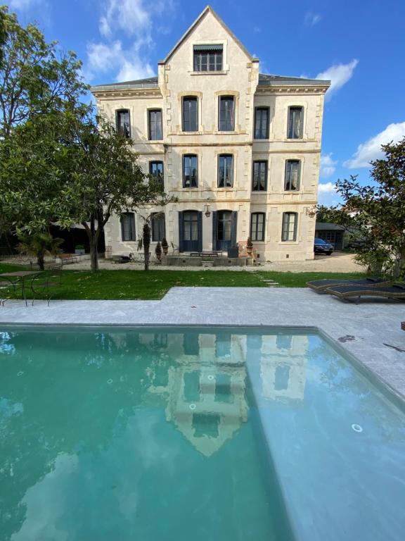 - un grand bâtiment avec une piscine en face dans l'établissement Demeure Saint Louis, Cité 10mn à pieds, PARKING Privé, BORNES 7,2 KW, AC, FULL WIFI, à Carcassonne