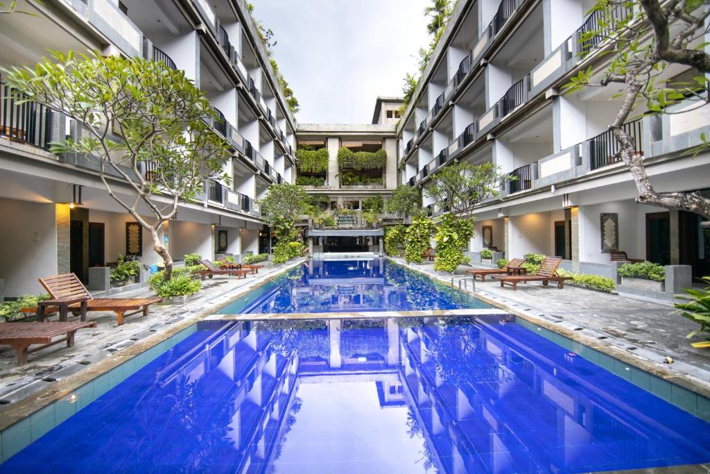 a swimming pool in the middle of a building at Champlung Mas Hotel Legian, Kuta in Legian