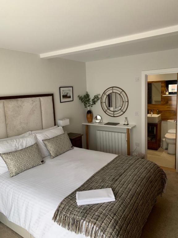 a bedroom with a white bed with a book on it at The Burrow at Tankerton in Whitstable