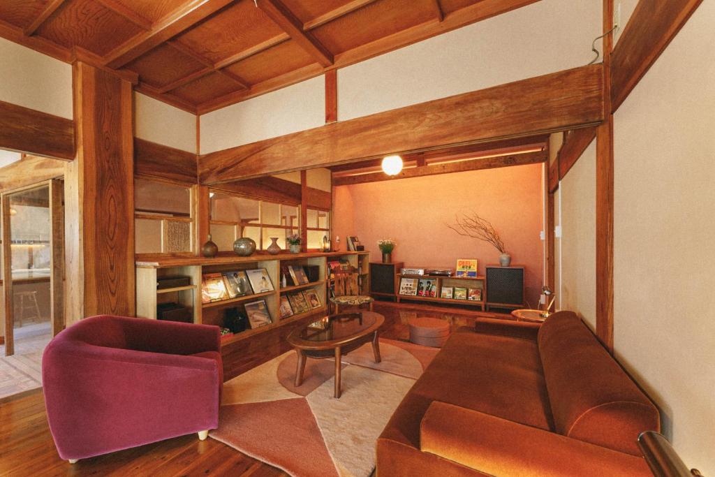 a living room with a couch and a table at Kominkayado LOOF Sakanoie in Fuefuki