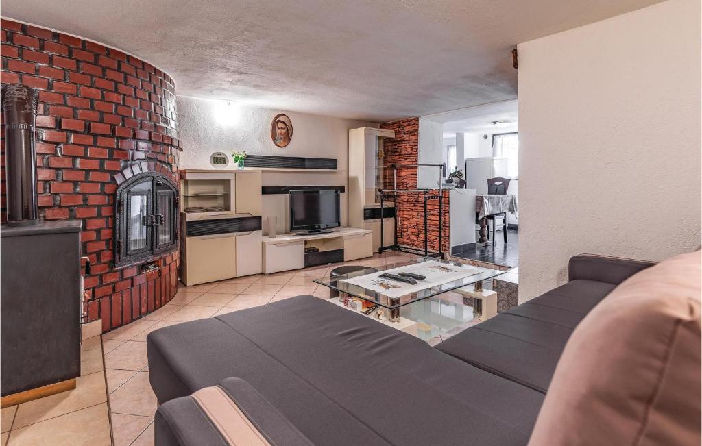 Awesome Apartment In Liznjan With Wifi في ليجيان: غرفة معيشة مع أريكة وجدار من الطوب