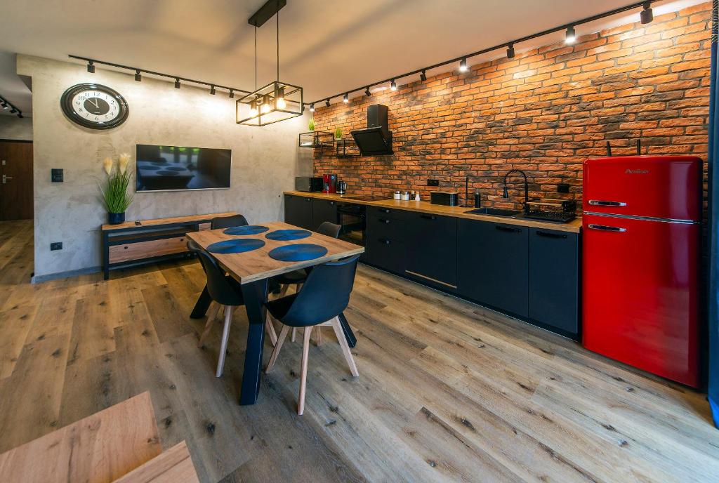 a kitchen with a wooden table and a red refrigerator at Apartament Sun & Ski - Loft in Podgórzyn