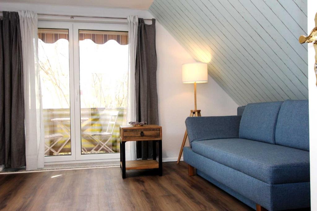 a living room with a blue couch and a window at Lieblingshaus Fiete in Prerow