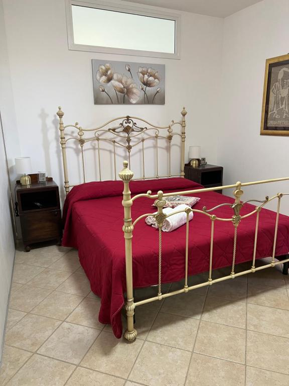 a bedroom with a bed with a red bedspread at Baglio Cracchiolo da Tuzzo - Casa Il Limone in San Vito lo Capo