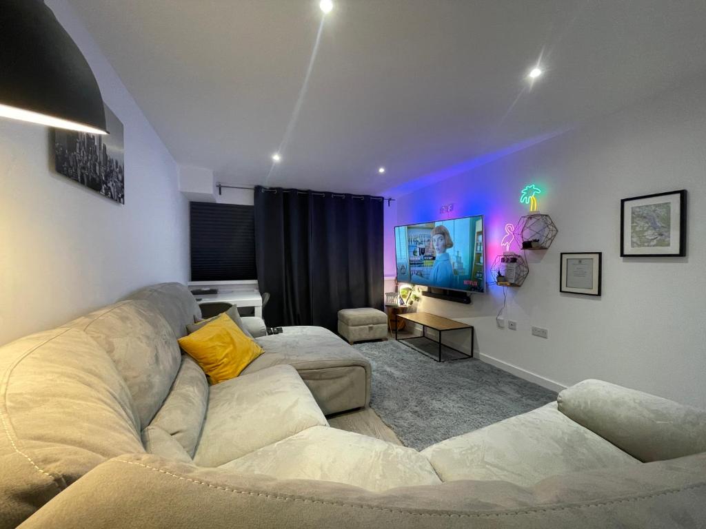 a living room with a couch and a tv at Smart Apartment close to Watford Atria and Station in Watford