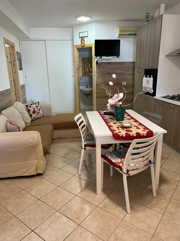 ein Wohnzimmer mit einem Tisch und 2 Stühlen in der Unterkunft Baglio Cracchiolo da Tuzzo - Casa Il Limone in San Vito lo Capo