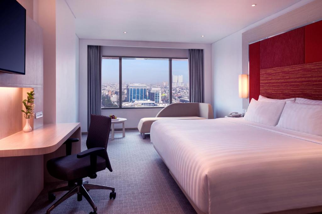 Postel nebo postele na pokoji v ubytování Grand Mercure Jakarta Harmoni