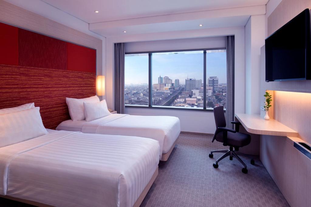 Postel nebo postele na pokoji v ubytování Grand Mercure Jakarta Harmoni