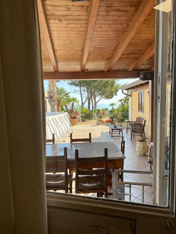 vista su un patio con tavolo e sedie di Baglio Cracchiolo da Tuzzo - Casa Il Limone a San Vito lo Capo