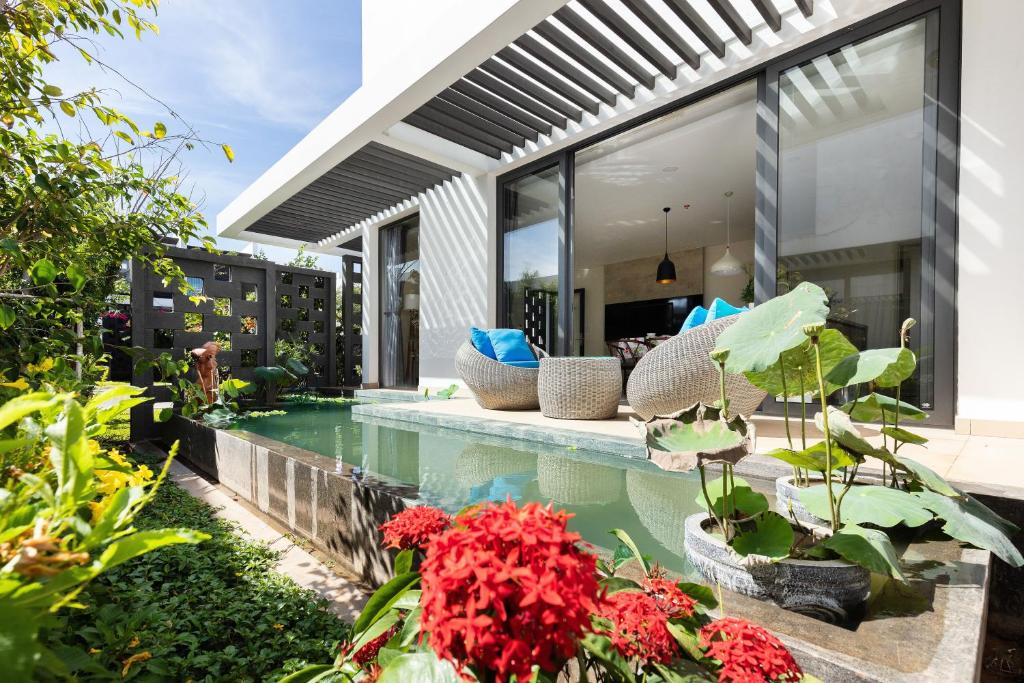 ein Haus mit einem Pool und einigen Pflanzen und Blumen in der Unterkunft Okinawa Villas and Beach Club - Oceanami Resort in Long Hải