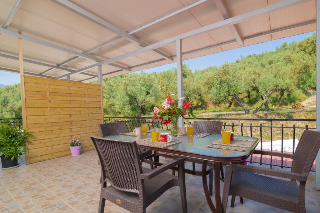 un patio con mesa, sillas y una valla en Arokaria apartment en Alikanas