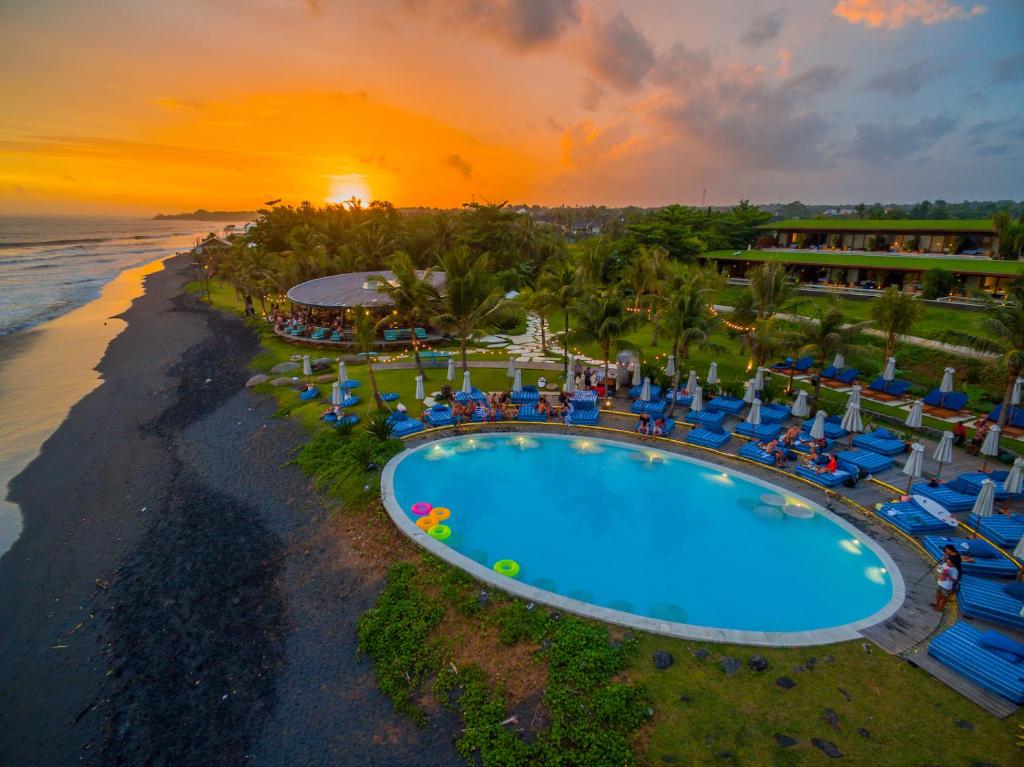 ein Luftblick auf ein Resort mit Pool und Strand in der Unterkunft Hotel Komune and Beach Club Bali in Keramas