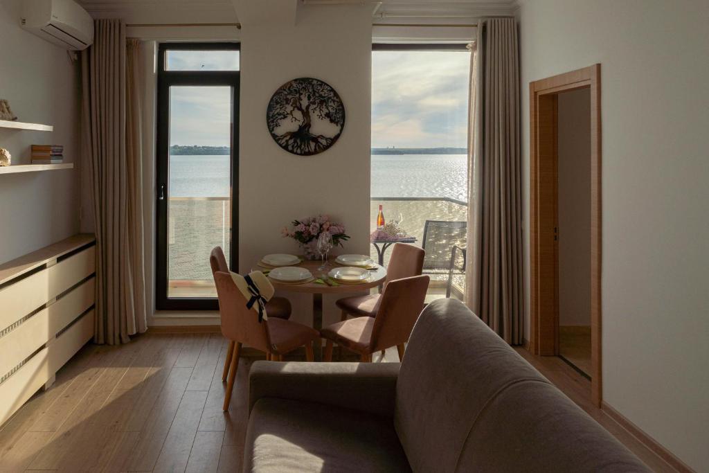 uma sala de estar com um sofá e uma mesa com cadeiras em Apartament Le Bonheur em Mamaia